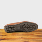 Outsole of Brick leather loafer on a wooden surface with a white background