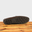 Outsole of Moor leather loafer on a wooden surface with a white background
