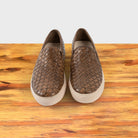 A Pair of Moor woven slip-on shoe on a wooden surface with a white background