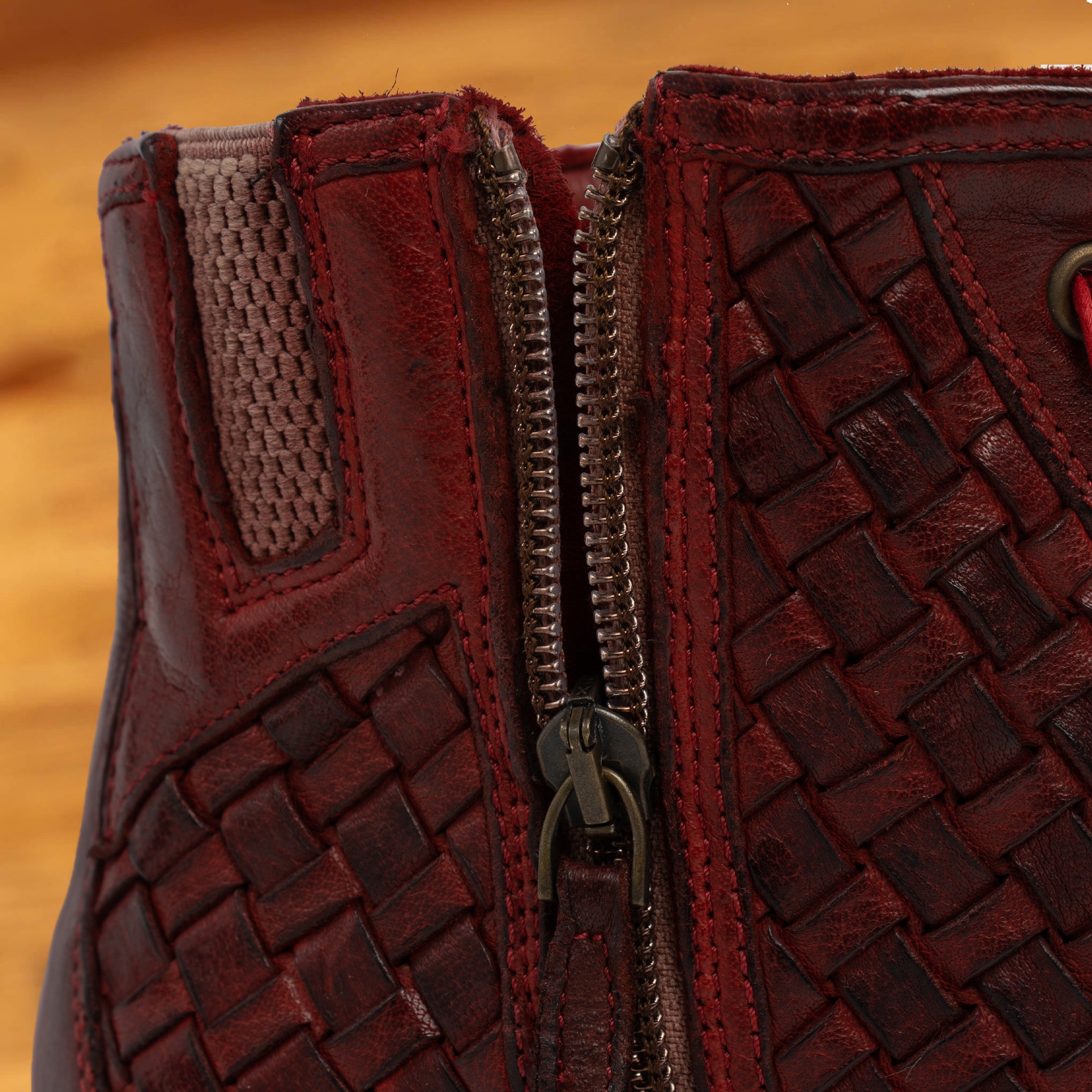 Cherry high-top sneaker with woven pattern on a wooden surface