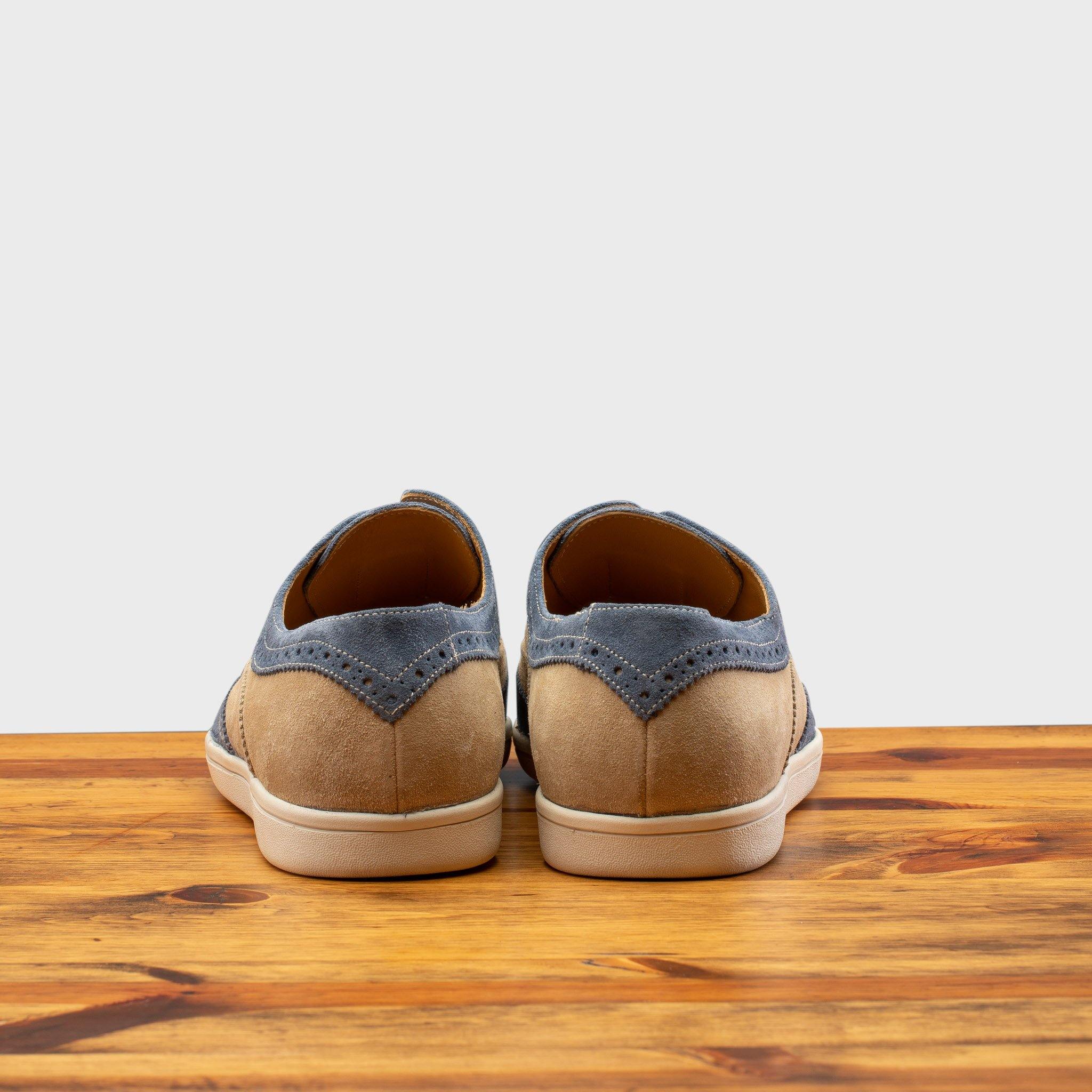 Pair of Two-tone shoe with beige and blue design on a wooden surface