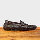 Dark Brown crocodile-patterned loafer on a wooden surface with a light gray background