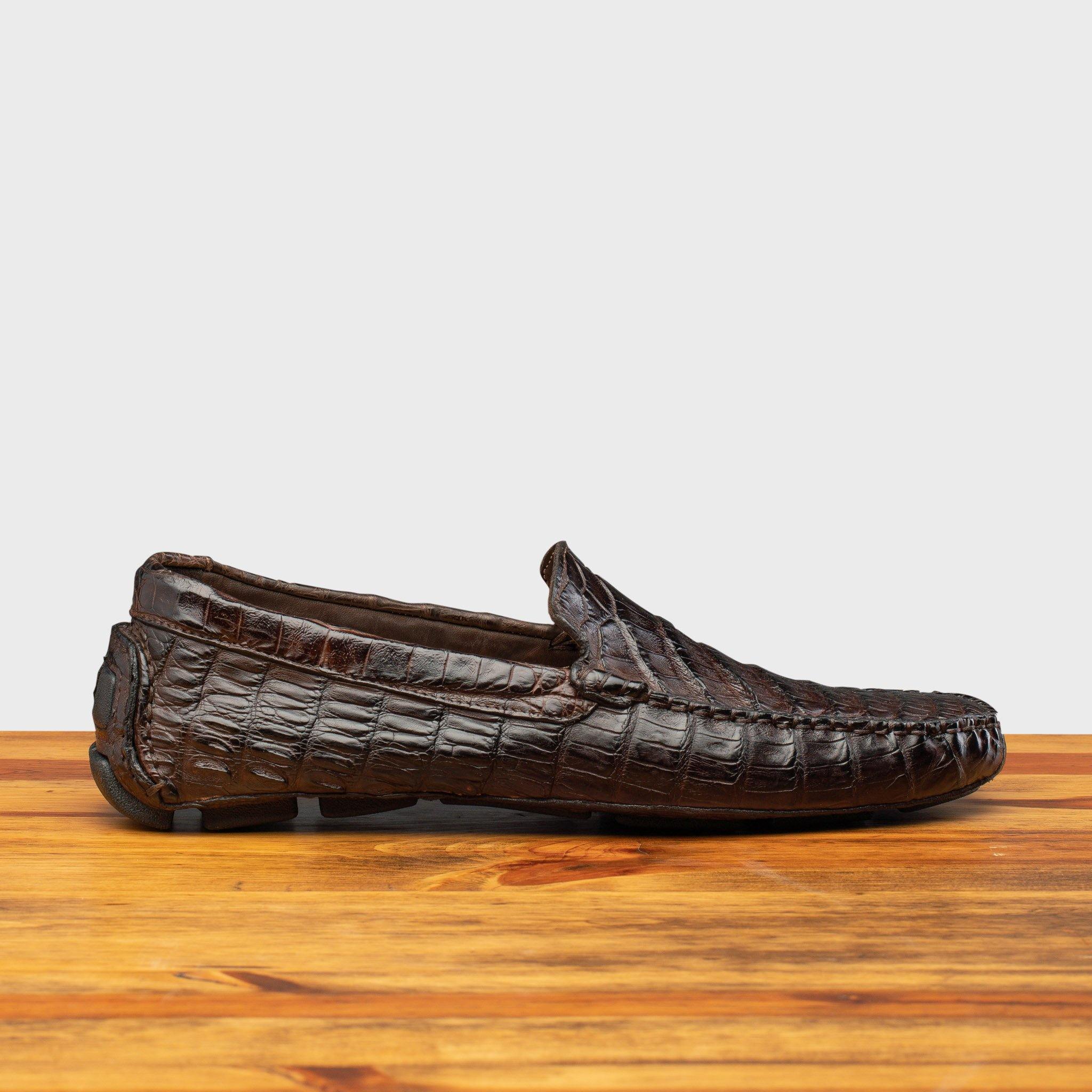 Dark Brown crocodile-patterned loafer on a wooden surface with a light gray background