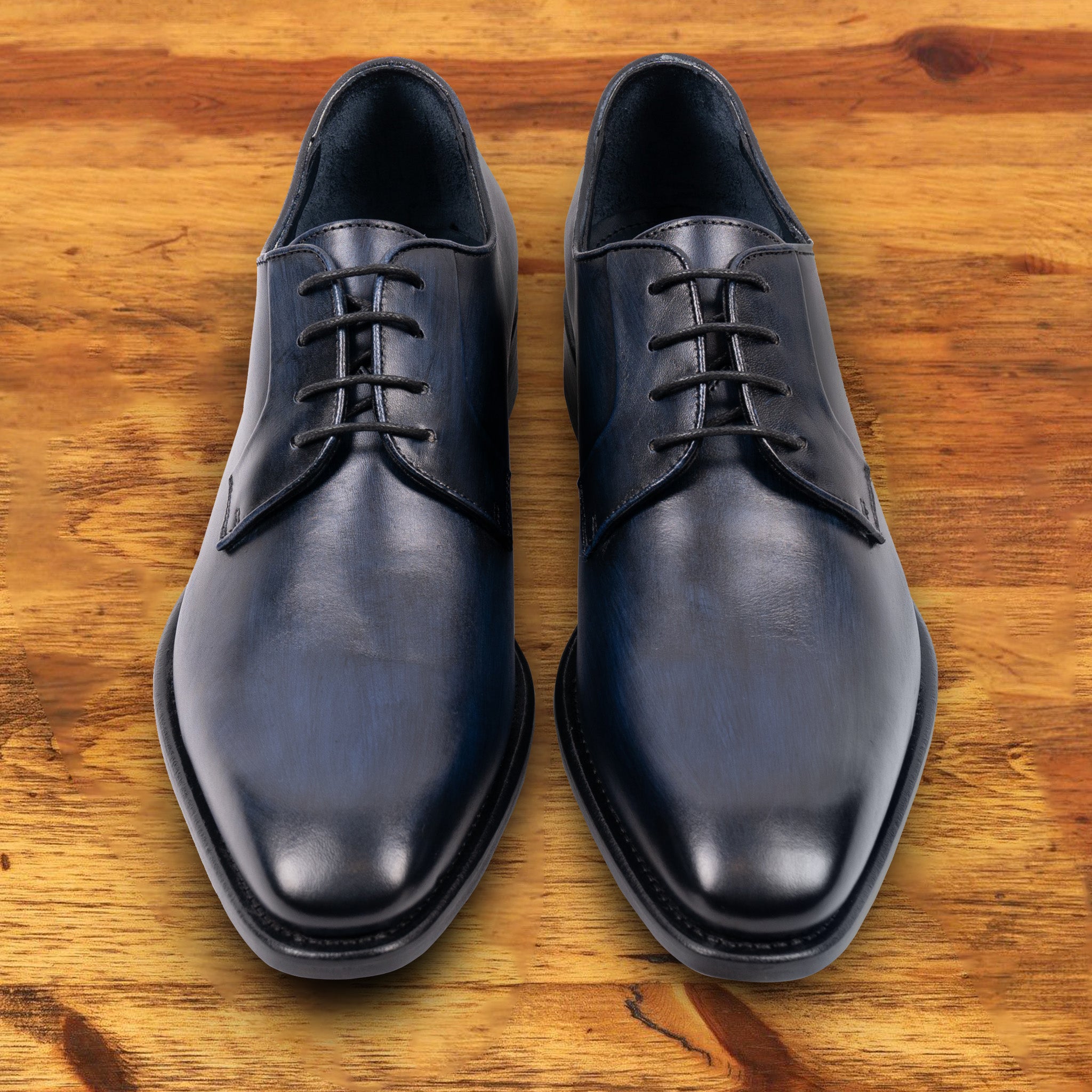 A Pair of Blue leather dress shoe on a wooden surface