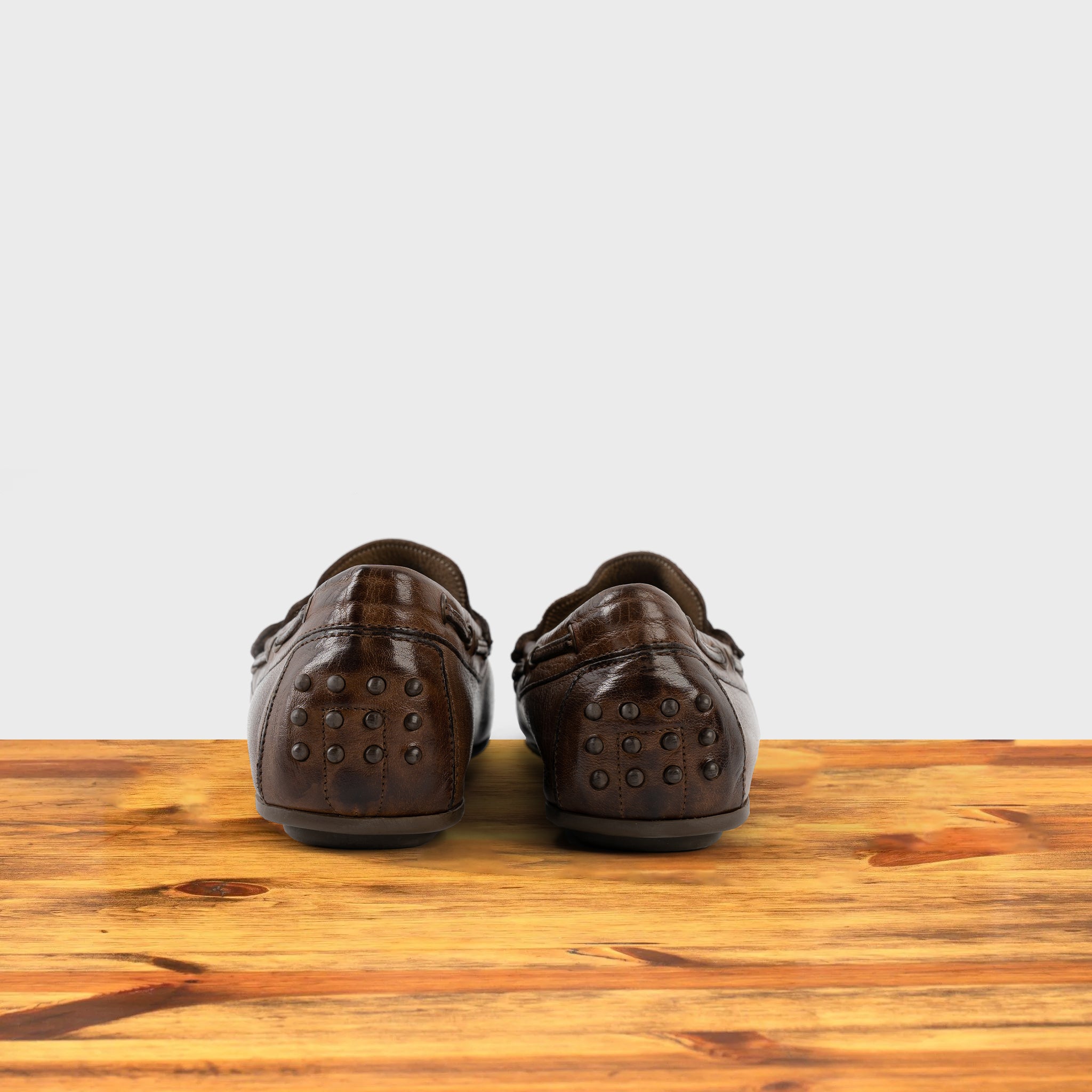 A Pair of Moor leather loafer on a wooden surface with a white background