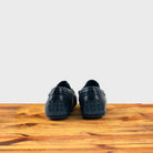A Pair of Blue leather loafer on a wooden surface with a white background