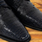 A Pair of Blue pstrich  dress shoe with studded details on a wooden surface