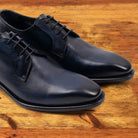 A Pair of Blue leather dress shoe on a wooden surface