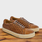 A Pair of Brick woven sneaker on a wooden surface with a light gray background