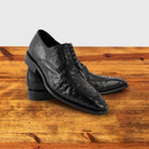 A Pair of Black dress shoe on a wooden surface with a light gray background