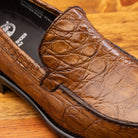 Close view of Brown leather loafer on a wooden surface