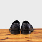 Back Side of Blue leather loafer on a wooden surface with a light gray background