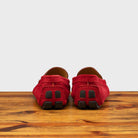 A Pair of Red loafer with gold embroidery on a wooden surface