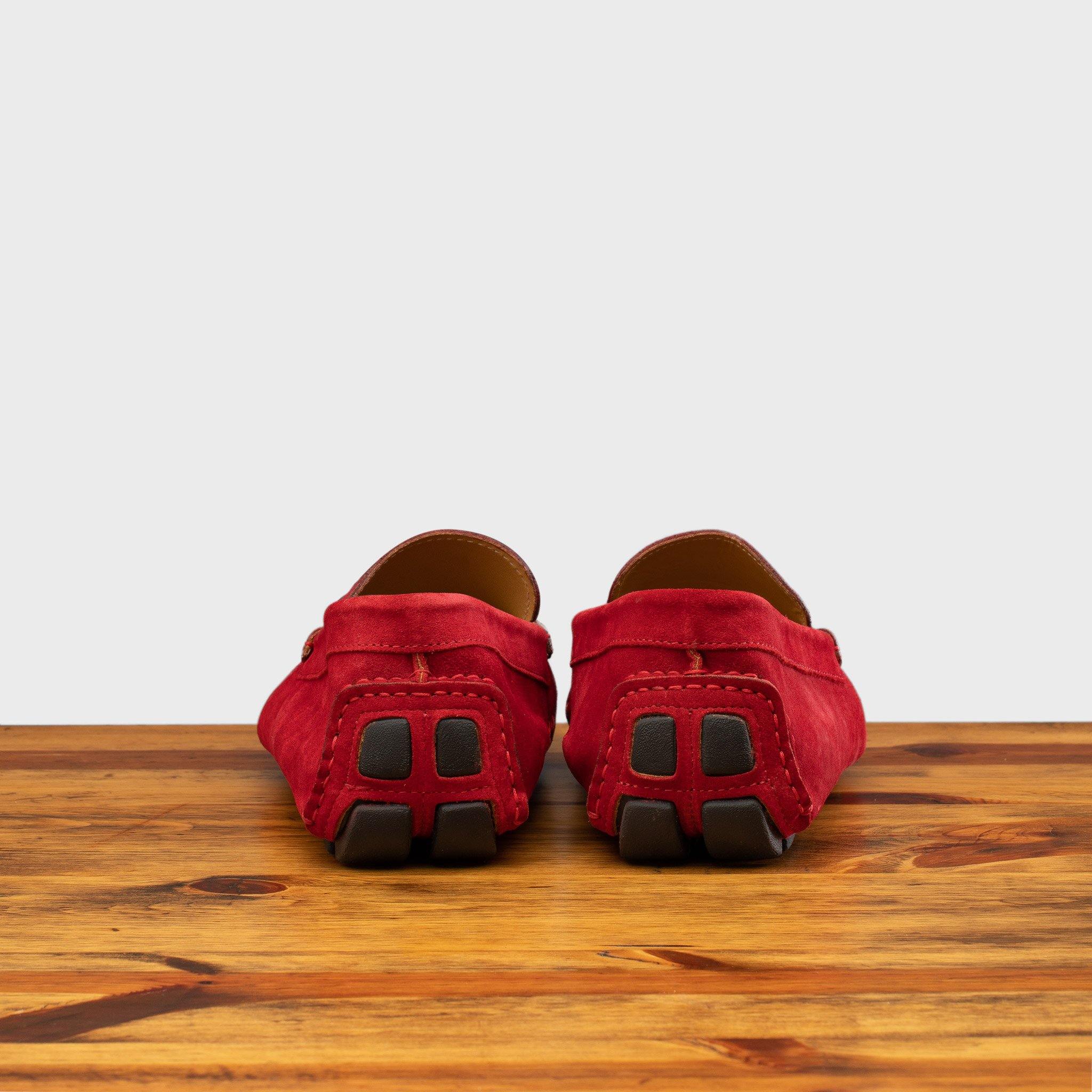 A Pair of Red loafer with gold embroidery on a wooden surface