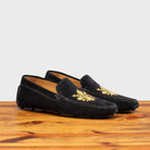 A Pair of Black loafer with gold embroidery on a wooden surface