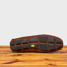Oustole of brick loafer with embroidery on a wooden surface