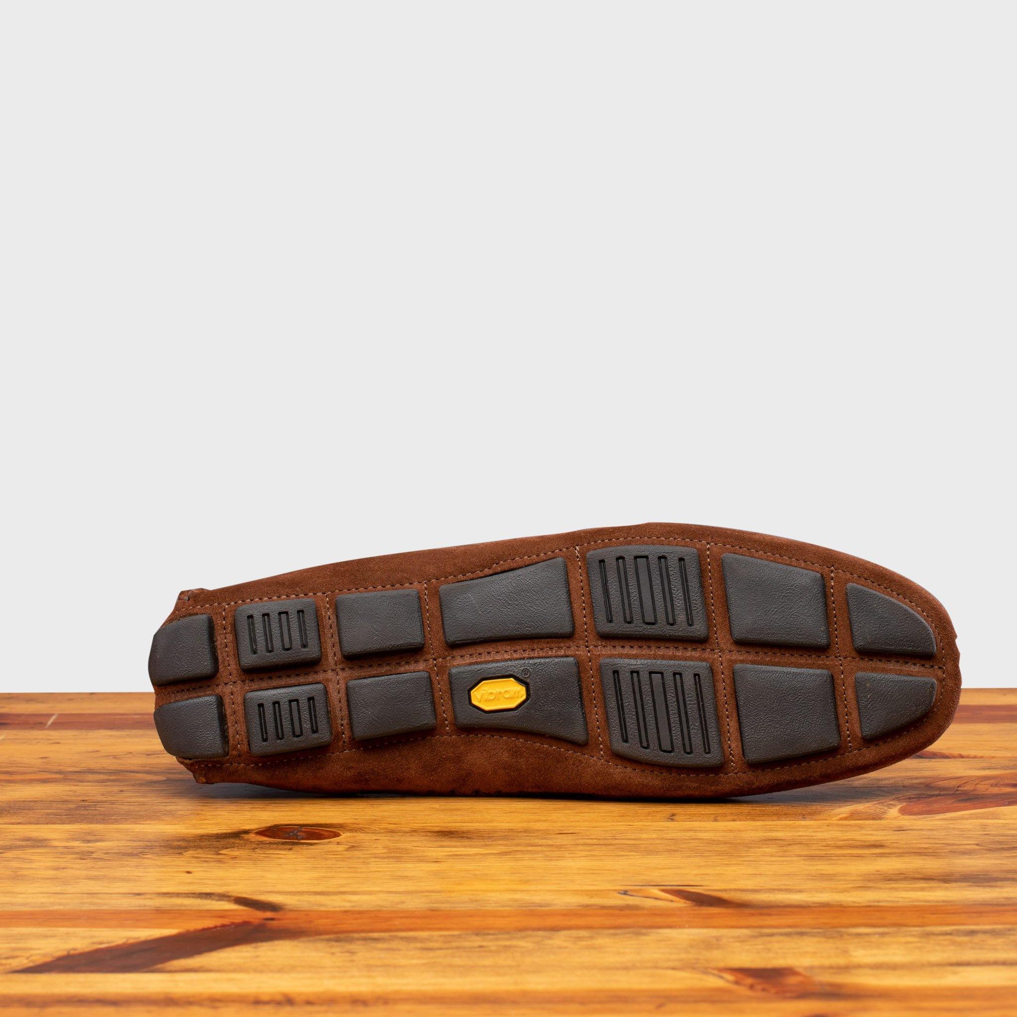 Oustole of brick loafer with embroidery on a wooden surface