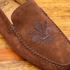 Brick loafer with embroidery on a wooden surface