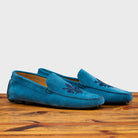 A Pair of Denim loafer with embroidery on a wooden surface