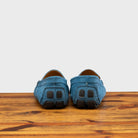 A Pair of Denim loafer with embroidery on a wooden surface