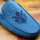 Denim loafer with embroidery on a wooden surface