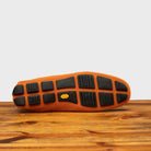 Outsole of Papaya loafer with embroidery on a wooden surface