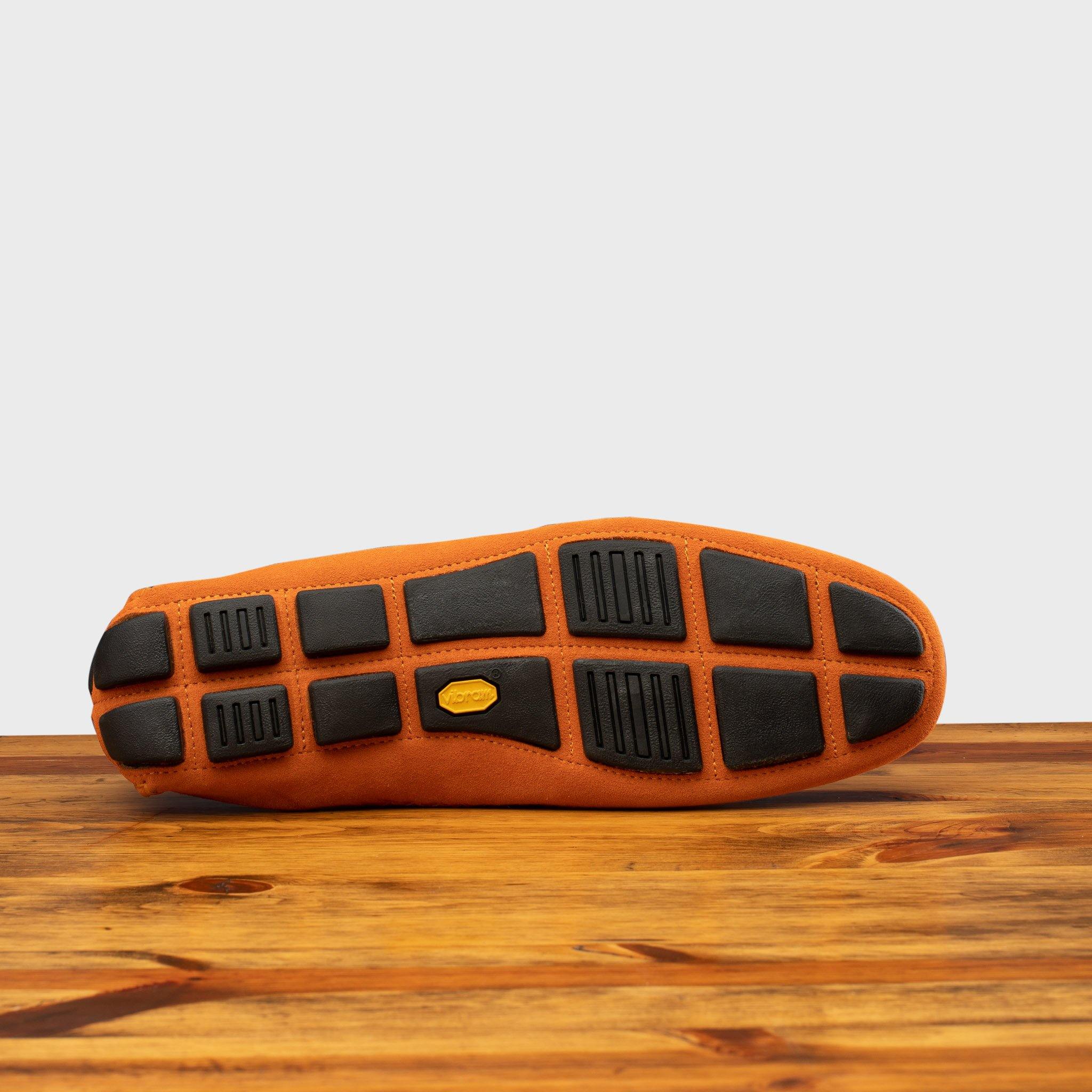 Outsole of Papaya loafer with embroidery on a wooden surface