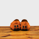 Papaya loafer with embroidery on a wooden surface