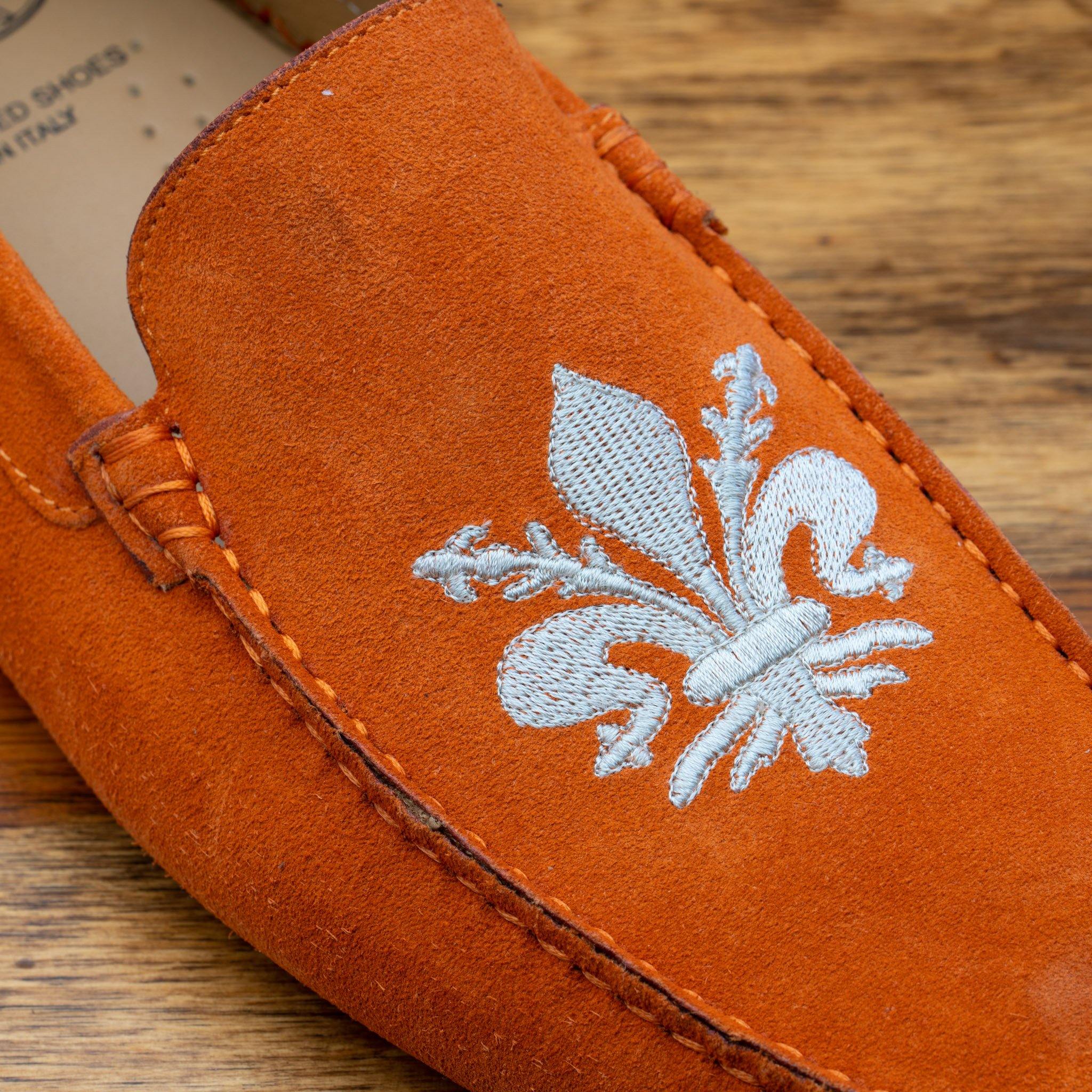 Papaya loafer with embroidery on a wooden surface
