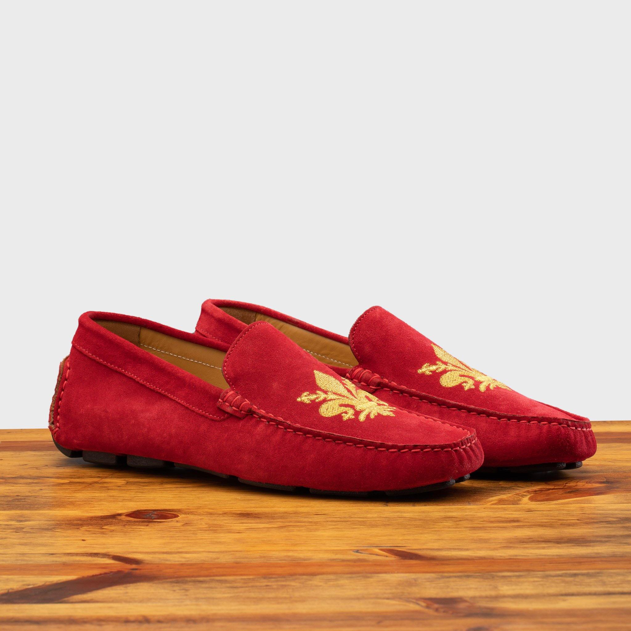 A Pair of Red loafer with gold embroidery on a wooden surface