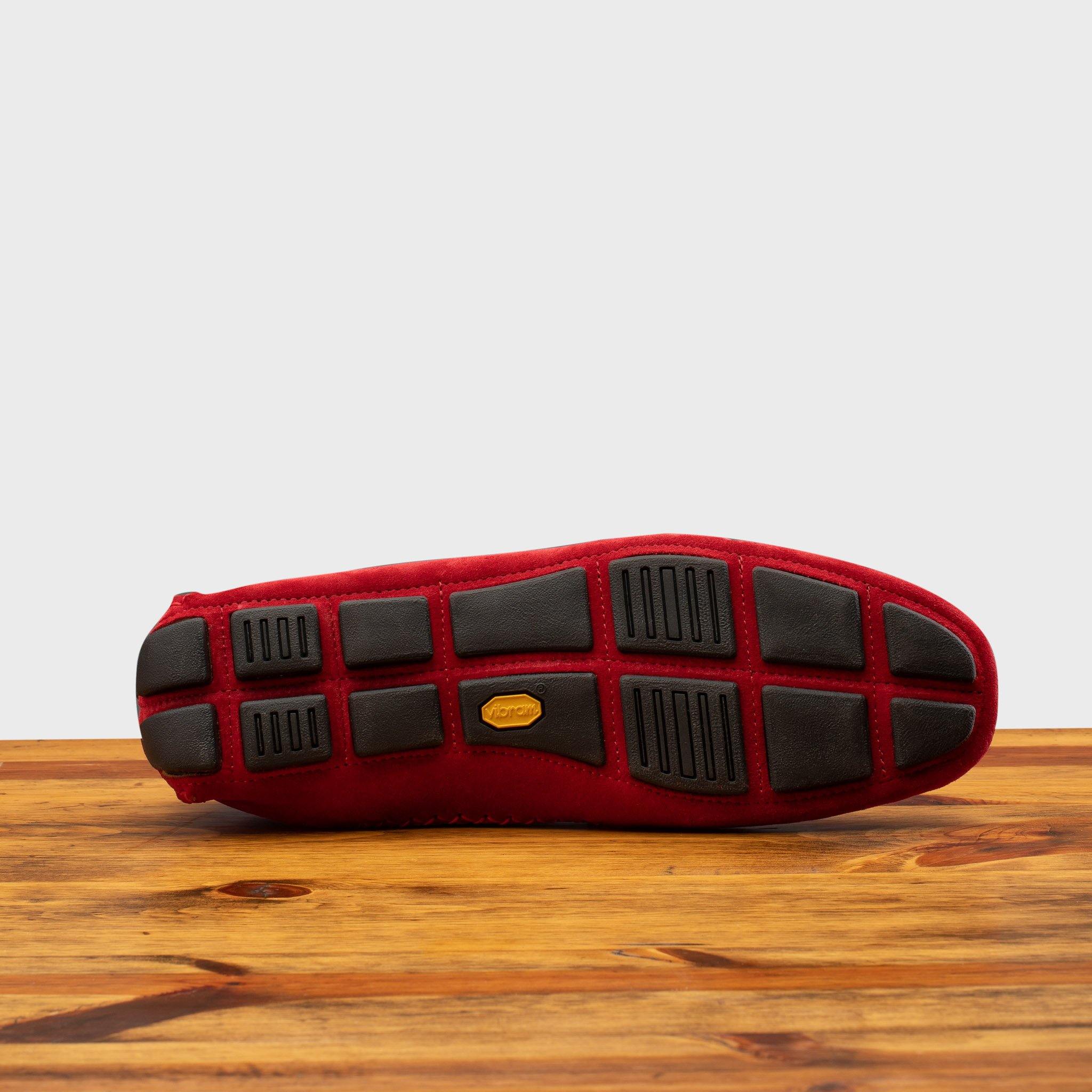 Outsole of Red loafer with gold embroidery on a wooden surface