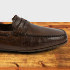 Moor leather loafer on a wooden surface with a white background