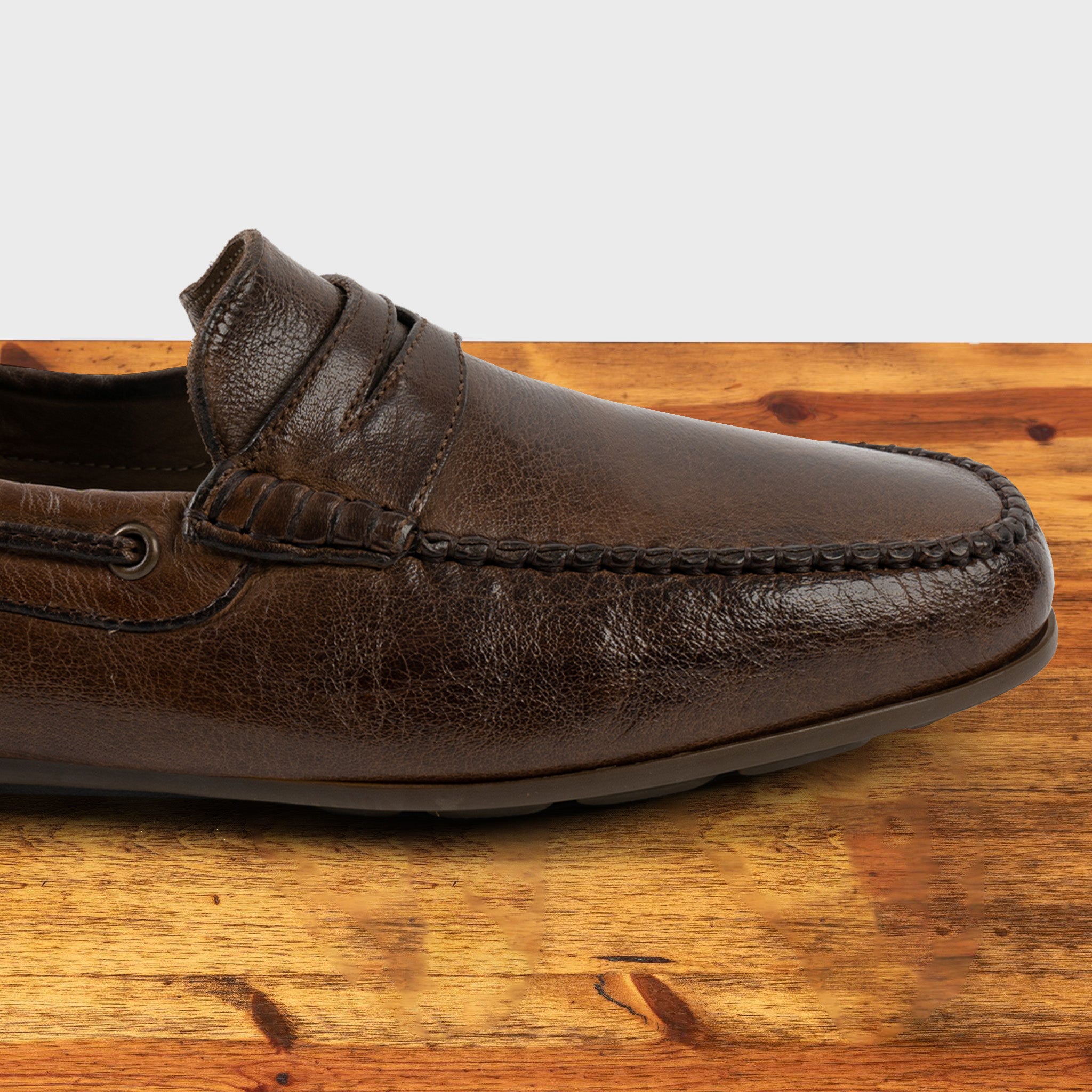 Moor leather loafer on a wooden surface with a white background