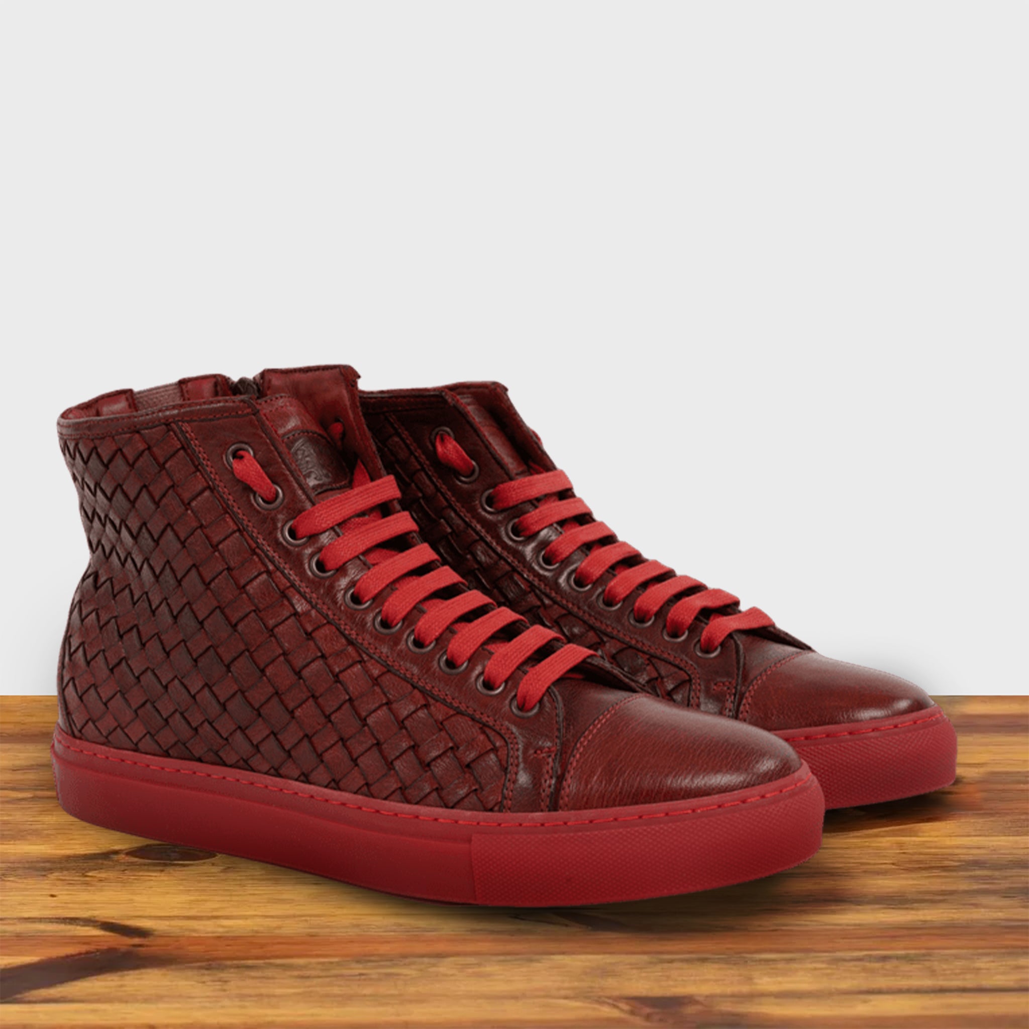 A Pair of Cherry high-top sneaker with woven pattern on a wooden surface