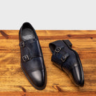 A Pair of Blue leather shoe with Double buckle on a wooden surface