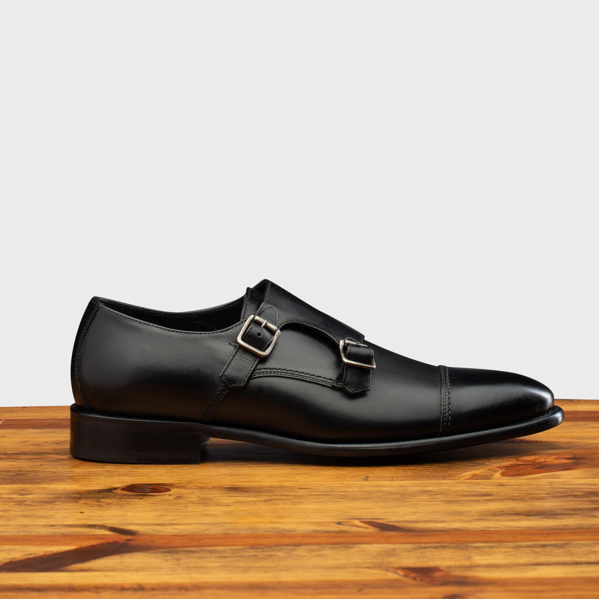 Black leather shoe with Double buckle on a wooden surface