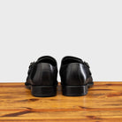 A Pair of black leather shoe with Double buckle on a wooden surface