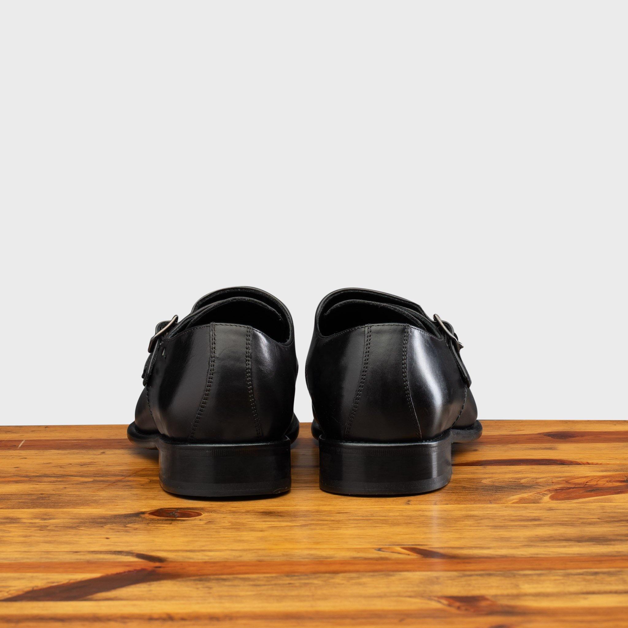 A Pair of black leather shoe with Double buckle on a wooden surface