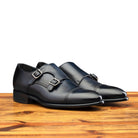 A Pair of Blue leather shoe with Double buckle on a wooden surface
