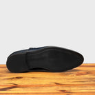 Outsole of blue leather shoe with Double buckle on a wooden surface