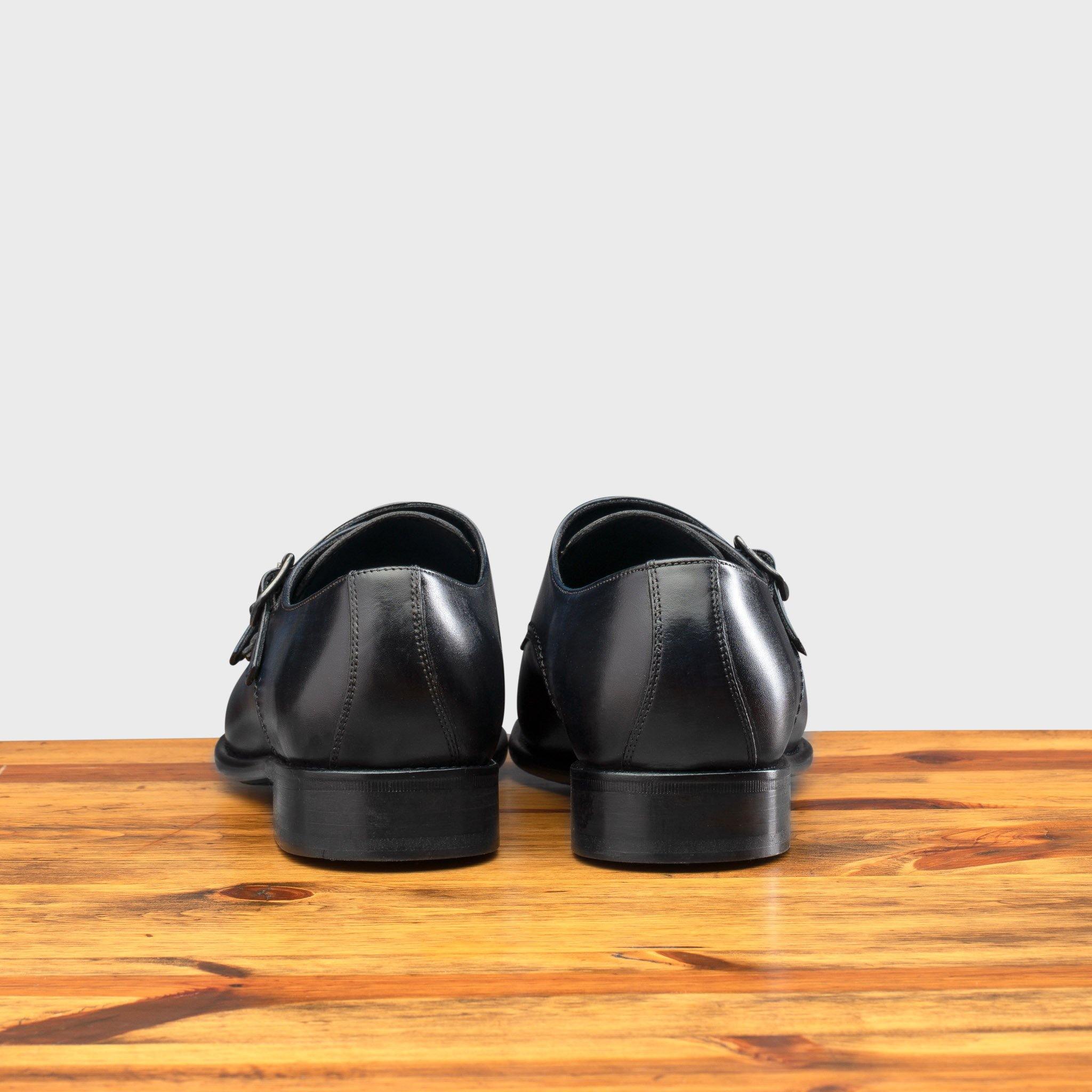 A Pair of Blue leather shoe with Double buckle on a wooden surface