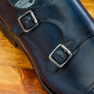 Blue leather shoe with Double buckle on a wooden surface
