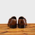 A Pair of Caramel leather shoe with Double buckle on a wooden surface