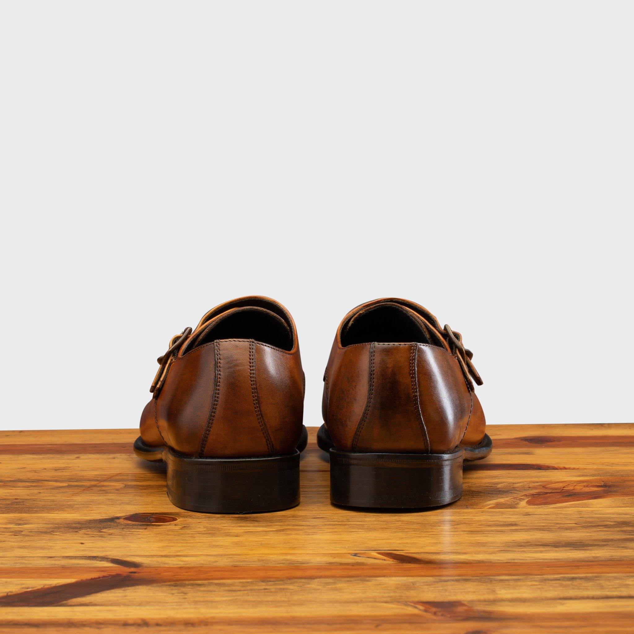 A Pair of Caramel leather shoe with Double buckle on a wooden surface