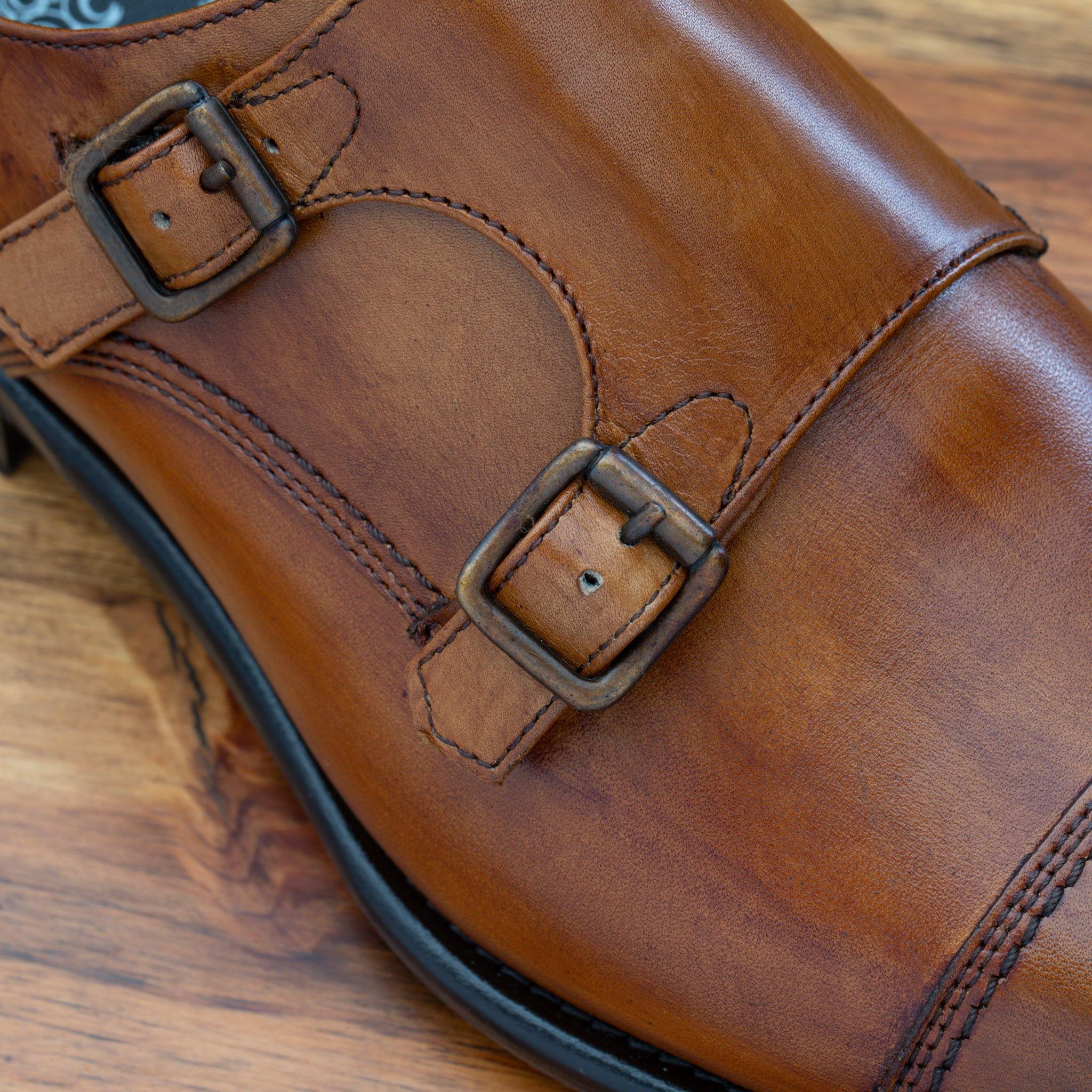 Caramel leather shoe with Double buckle on a wooden surface
