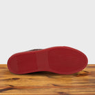 Outsole of Cherry  high-top sneaker with woven pattern on a wooden surface