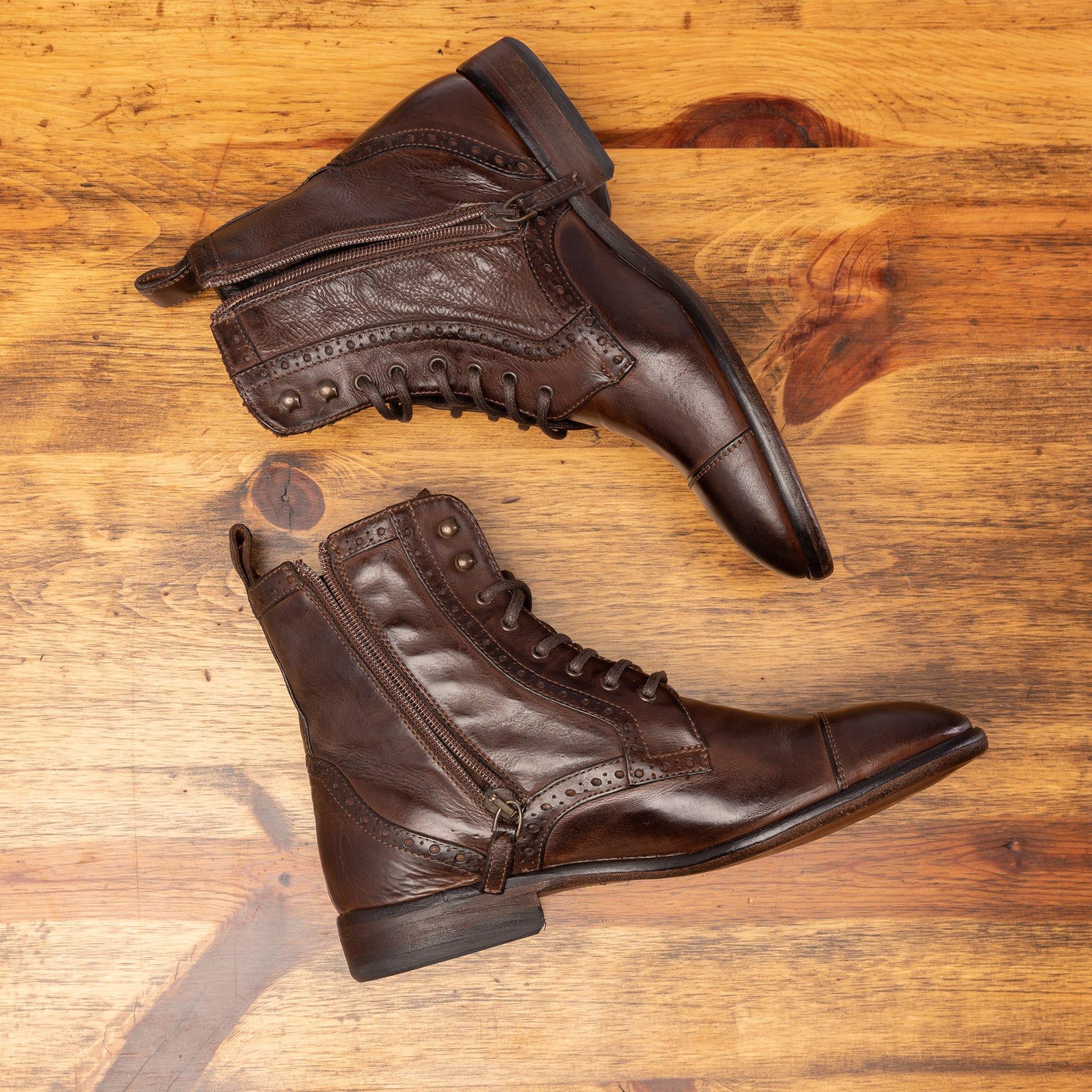 Side view of Brown leather boot on a wooden surface