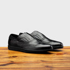 Pair of Black leather shoe on a wooden surface with a light gray background