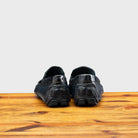 Back view of Blue leather loafer on a wooden surface with a light gray background