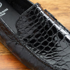 Close view of Black leather loafer on a wooden surface